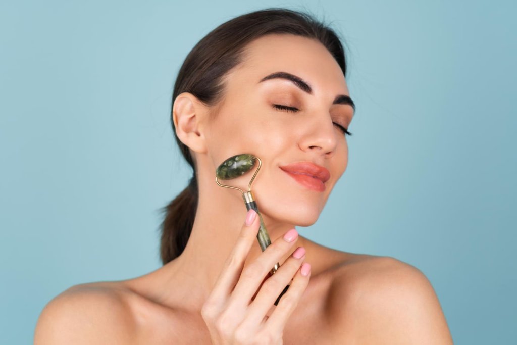 close-up-beauty-portrait-of-a-woman-with-perfect-skin-and-natural-make-up-plump-nude-lips-holding-a-roller-massager-for-face-and-neck (1).jpg